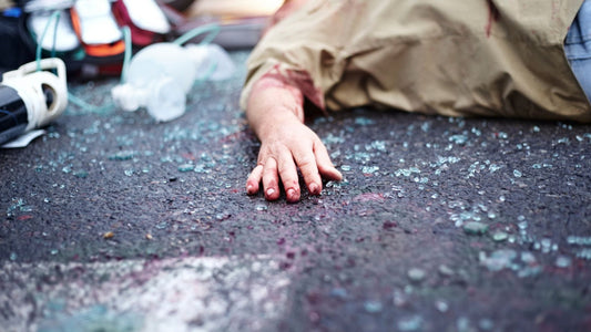 Person injured on the ground after a car accident