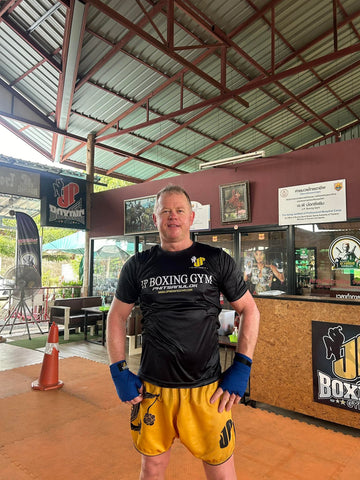 Man wearing yellow shorts standing in a boxing gym -gave first aid kit review
