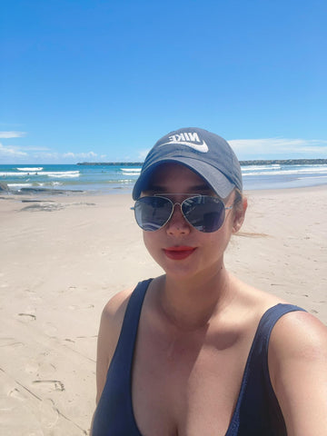 first aid kit customer on the beach with black sunnies.