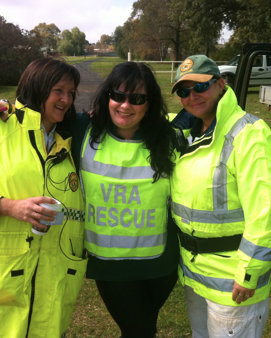 Sam Kerr with two people in VRA Rescue high-visibility jackets standing outdoors.