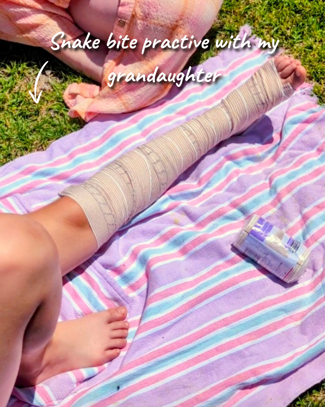 Pressure immobilisation bandage on a young girls leg, practicing what to do if a snake bite occurs.